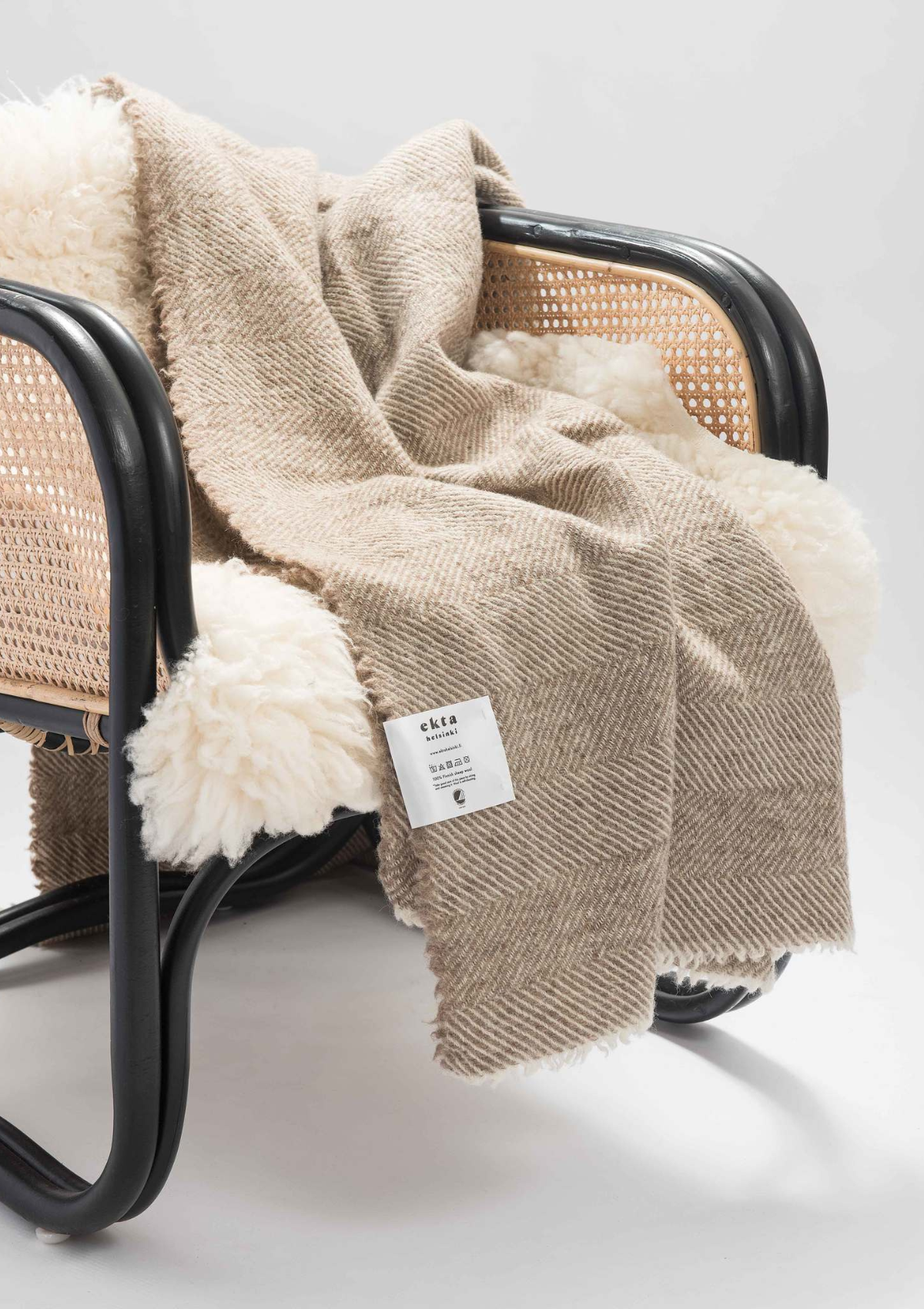 Herringbone pattern white and beige coloured throw made out of responsible Finnish sheep wool. Manufactured in Finland.